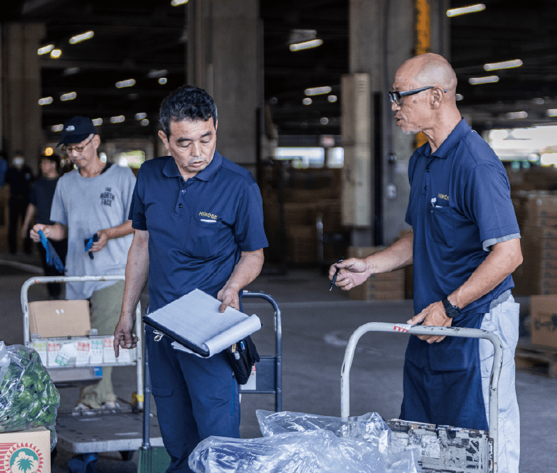 台車を使いながら話し合う作業員たち。